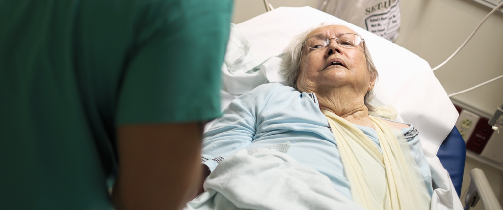 Neglected female nursing home patient laying in bed