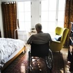 Lonely man sitting in a wheelchair in a nursing home