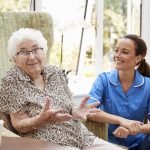 Elderly woman with aide in an assisted living facility