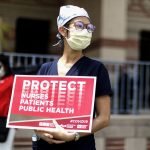 Frontline healthcare worker holding a protest sign