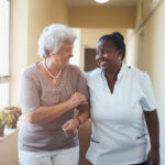 Smiling home caregiver and senior woman