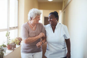 Smiling home caregiver and senior woman